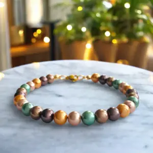 Mallorca parel armband met aardetinten oranje roze groen en bruin met gouden sluiting.