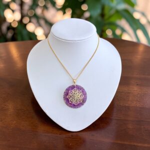 Orgonite hanger met Amethist 24 karaat goud, zilver.koper en messing op display violet flame