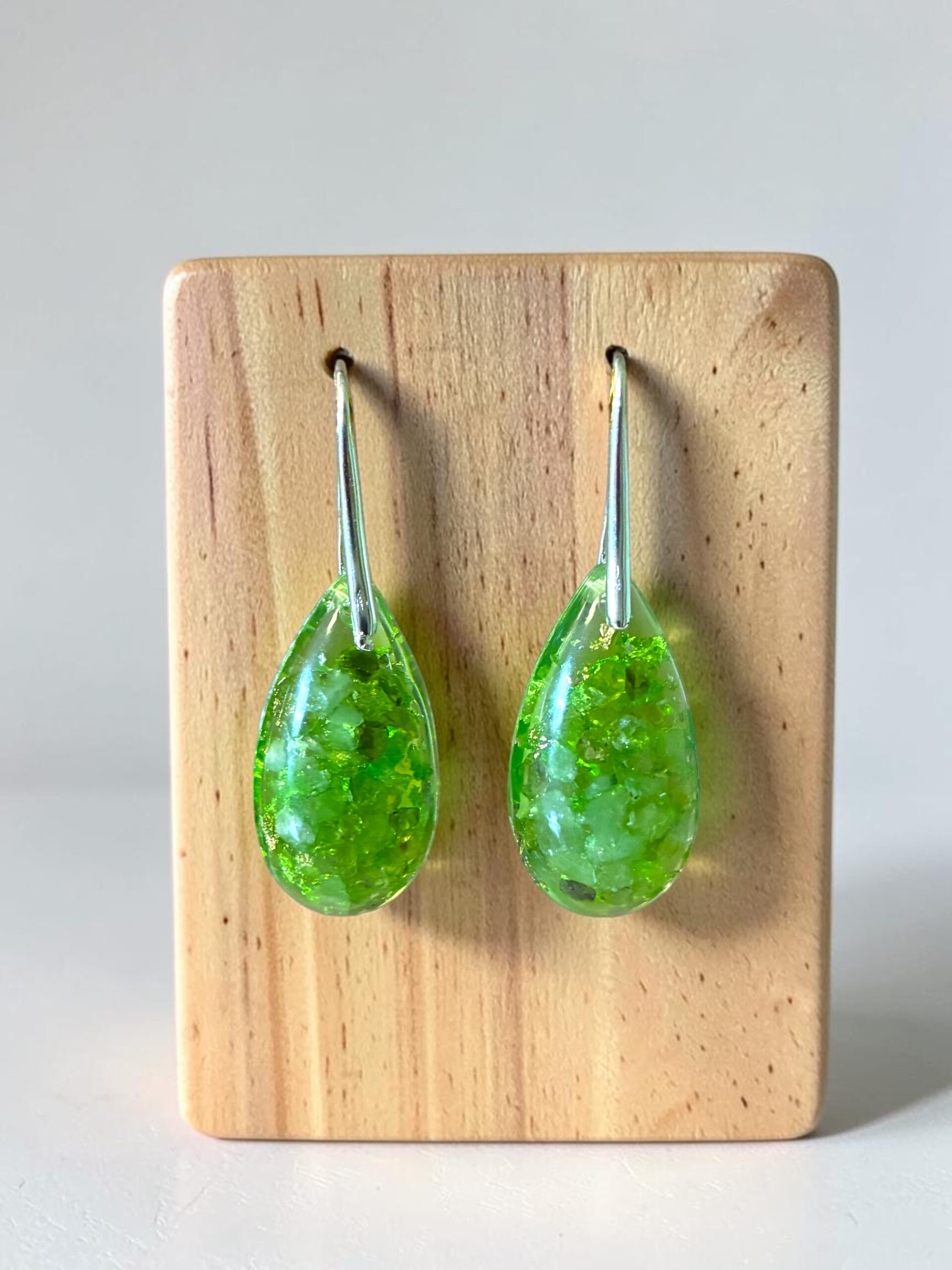 Handgemaakte orgonite oorhangers met peridoot, zilver & Cosmic Light Essence. Versterk je hartenergie, stimuleer innerlijke groei en bescherm je aura.